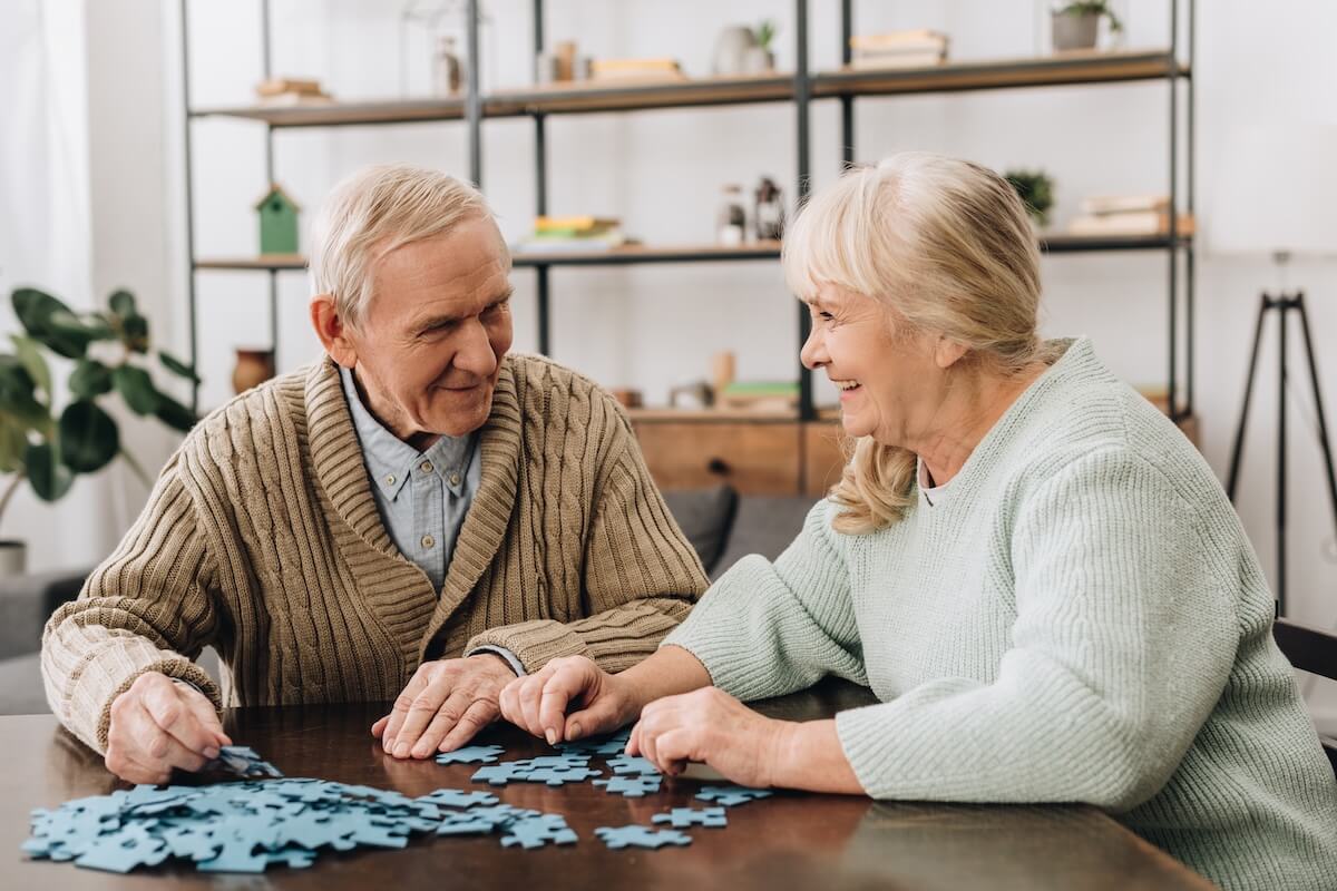 memory care in Pleasant Hill happy senior couple playing with puzzles at home